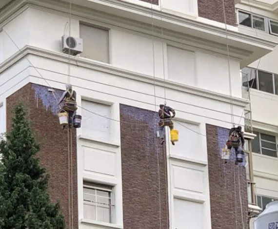 Equipo de Alta Group realizando trabajos de pintura y arenado en altura sobre fachada de edificio