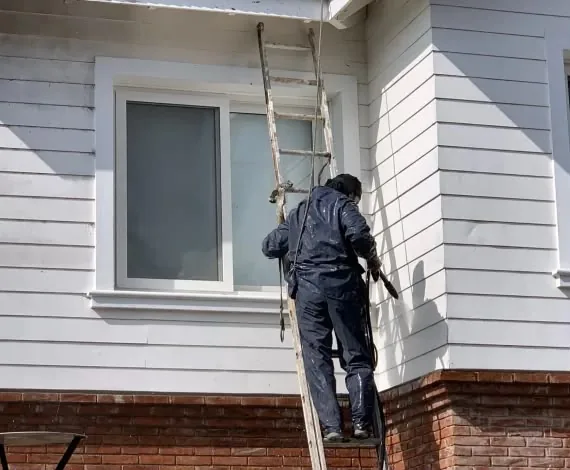 Operario de Alta Group realizando hidrolavado con vapor en fachada de ladrillo visto