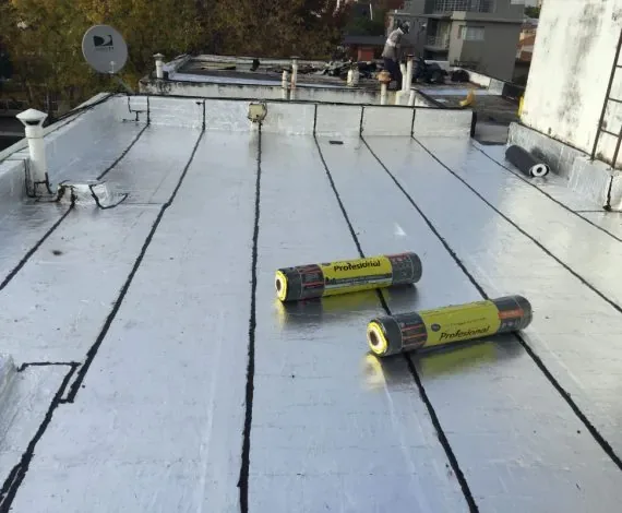 Rollos de membrana impermeabilizante instalados sobre cubierta de edificio